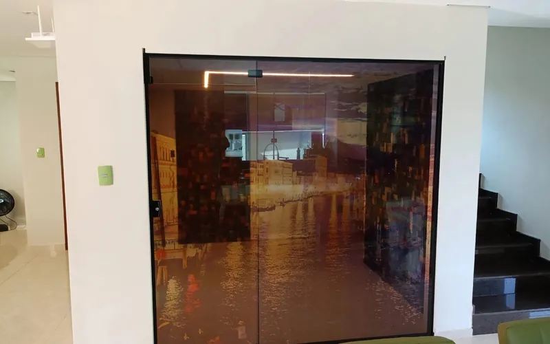 Porta de vidro fumê com perfil preto em sala de estar