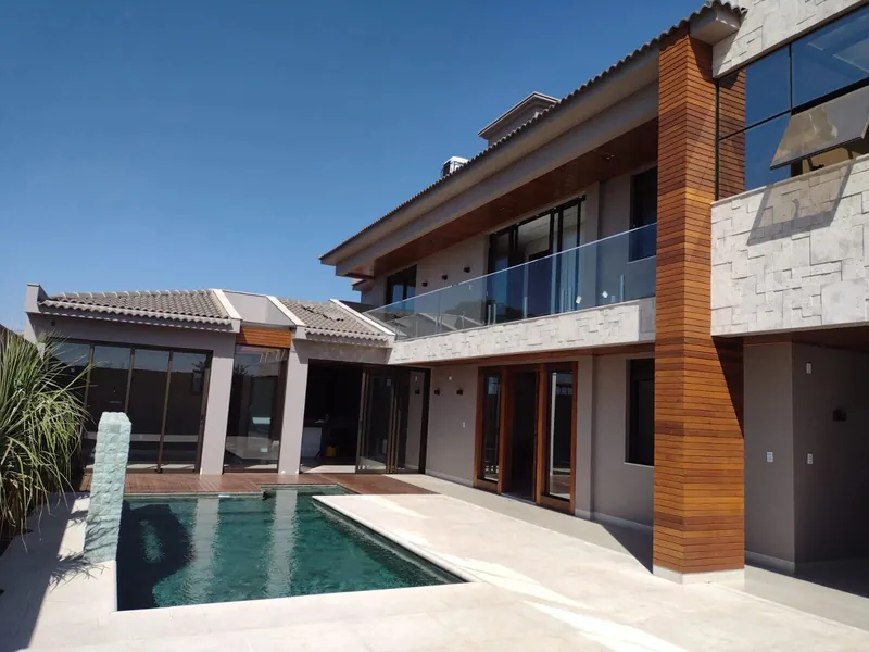 Casa com piscina, esquadrias de alumínio e guarda-corpo de vidro